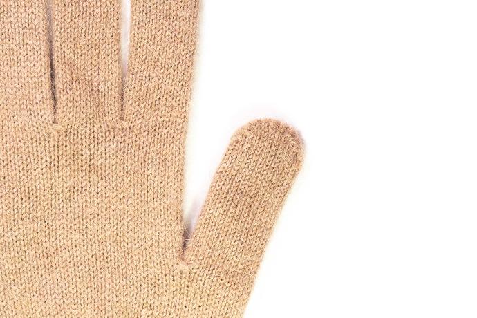 Detailaufnahme von beigen Fingerhandschuhen aus Kamelwolle