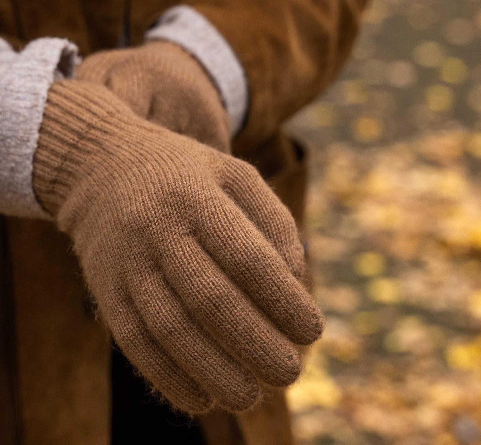Modellhand trägt braune Handschuhe aus Kamelwolle 