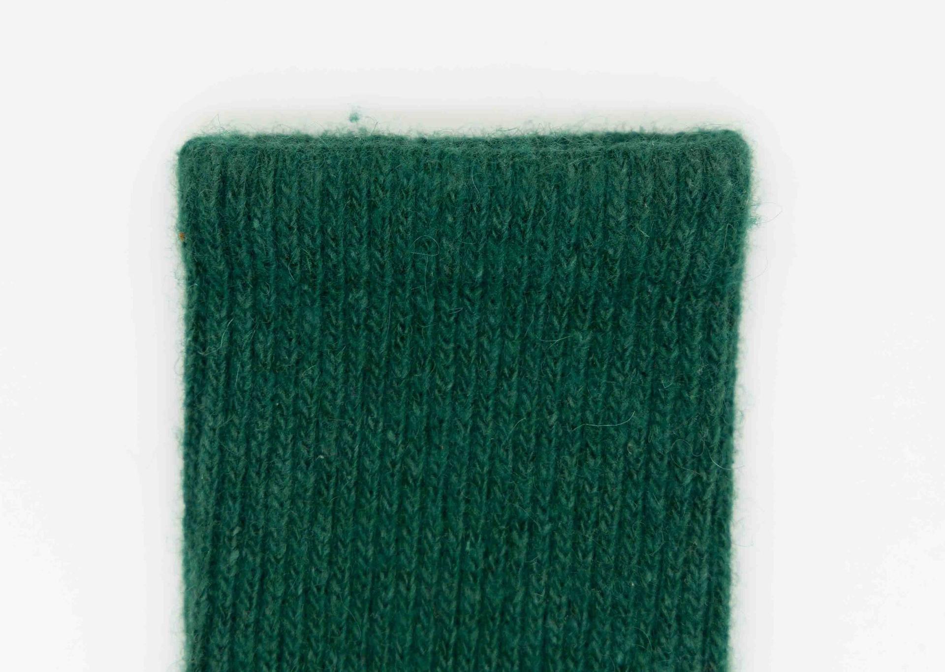Detailbild des Bundes eines tannengrünen Socken aus Schafwolle.