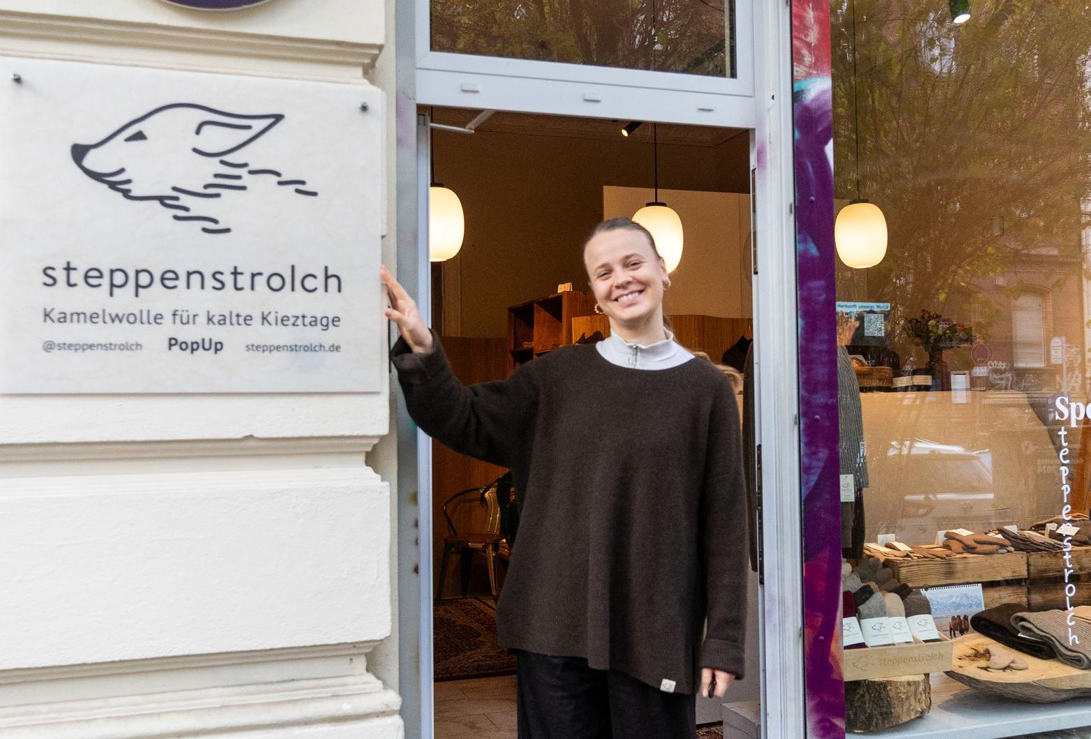 Eine Frau vor einem Ladengeschäft mit steppenstrolch Logo