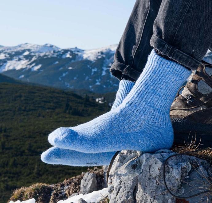 Blaue Wollsocken aus Schafwolle vor Alpenpanorama