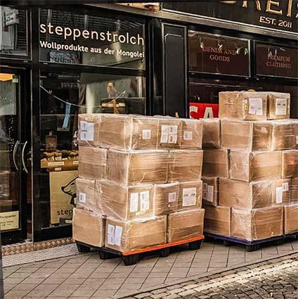 A delivery in front of our Aachen shop Two stacks of cardboard boxes in front of the steppenstrolch shop