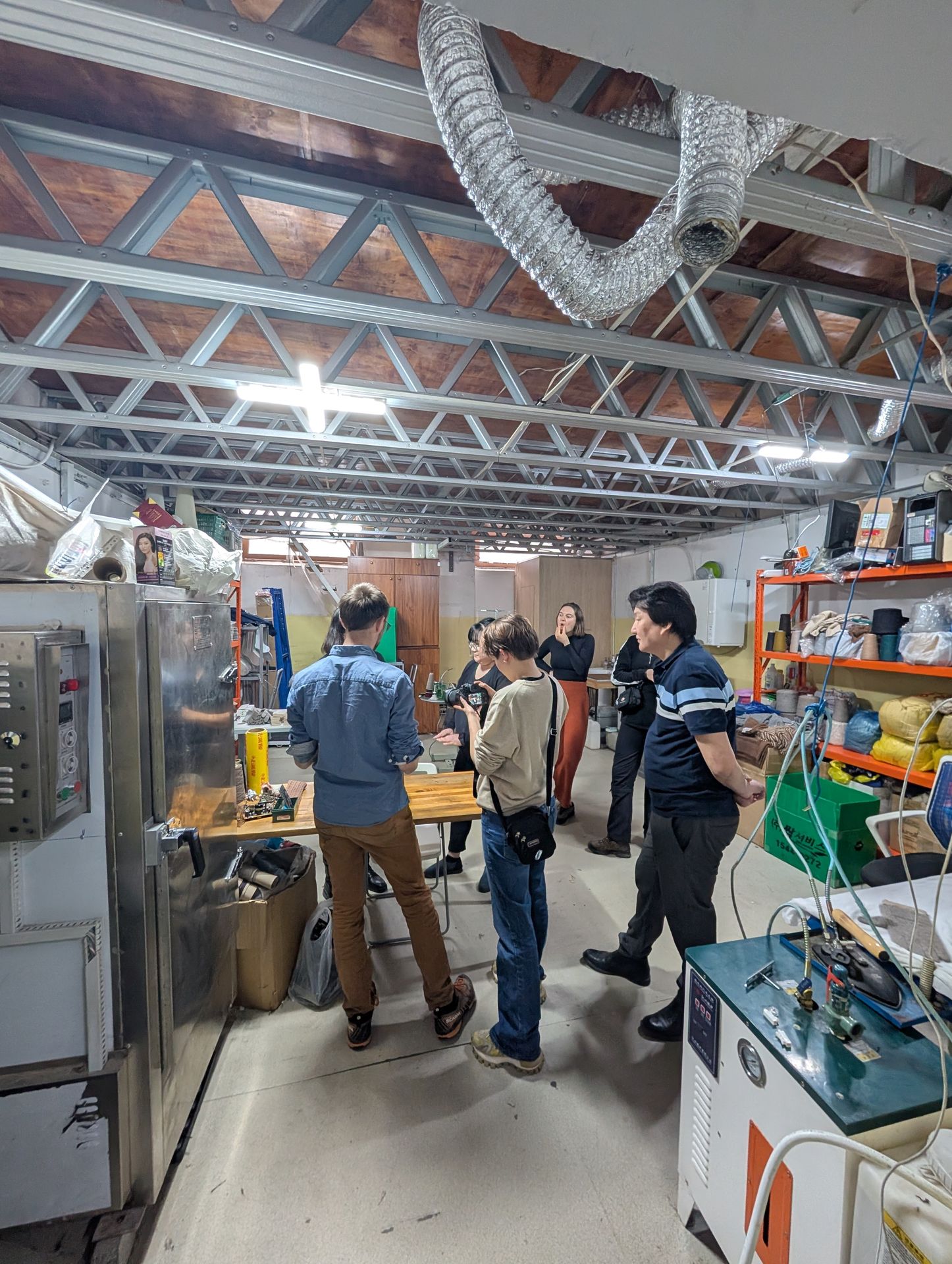Eine Gruppe von Menschen steht im Kreis in einer Fabrik