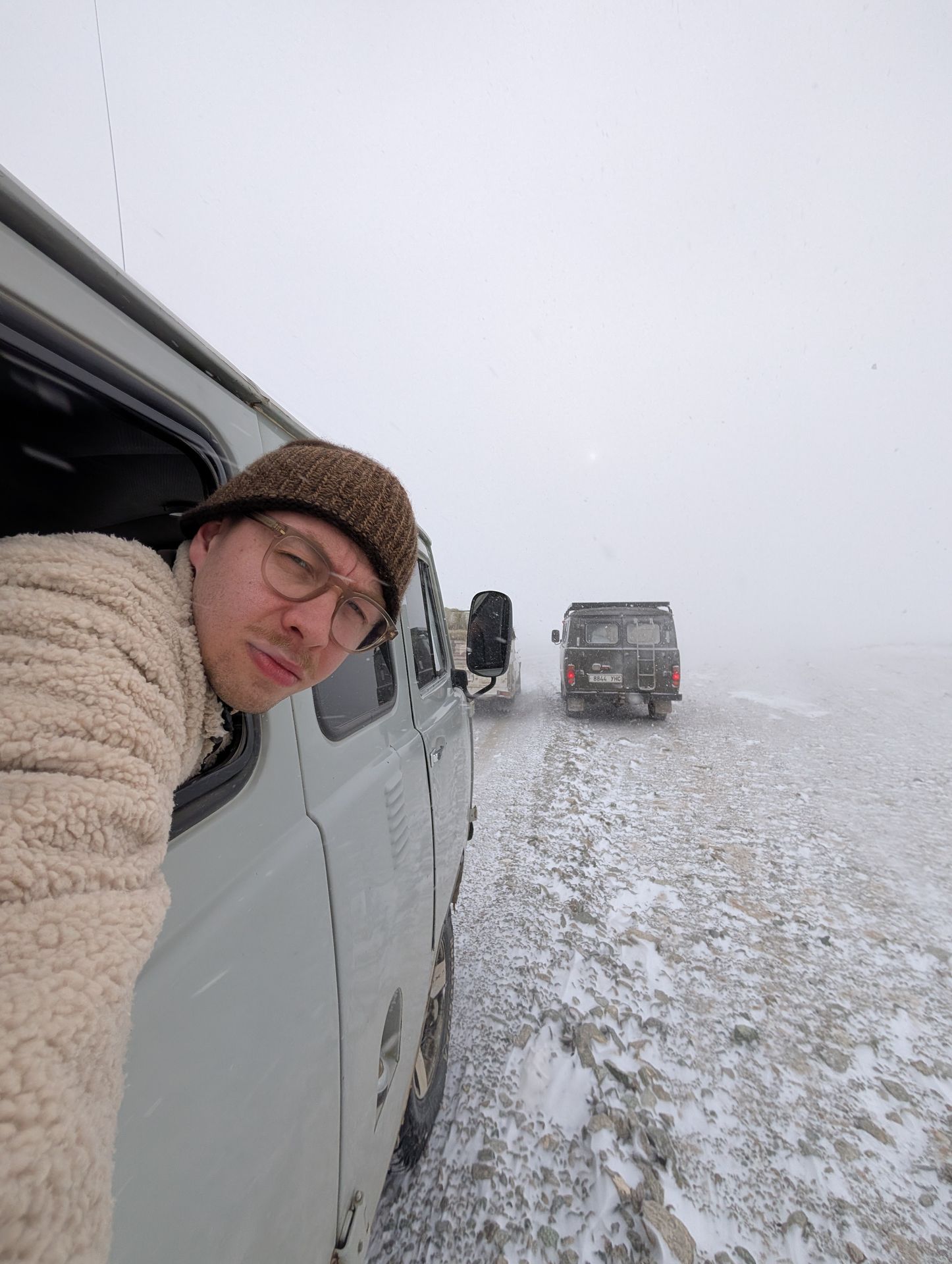Ein Mann macht ein Selfie aus einem Auto im Schneesturm