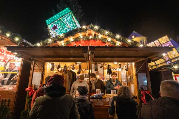 Wide-angle shot of a small, brightly lit Christmas market stall