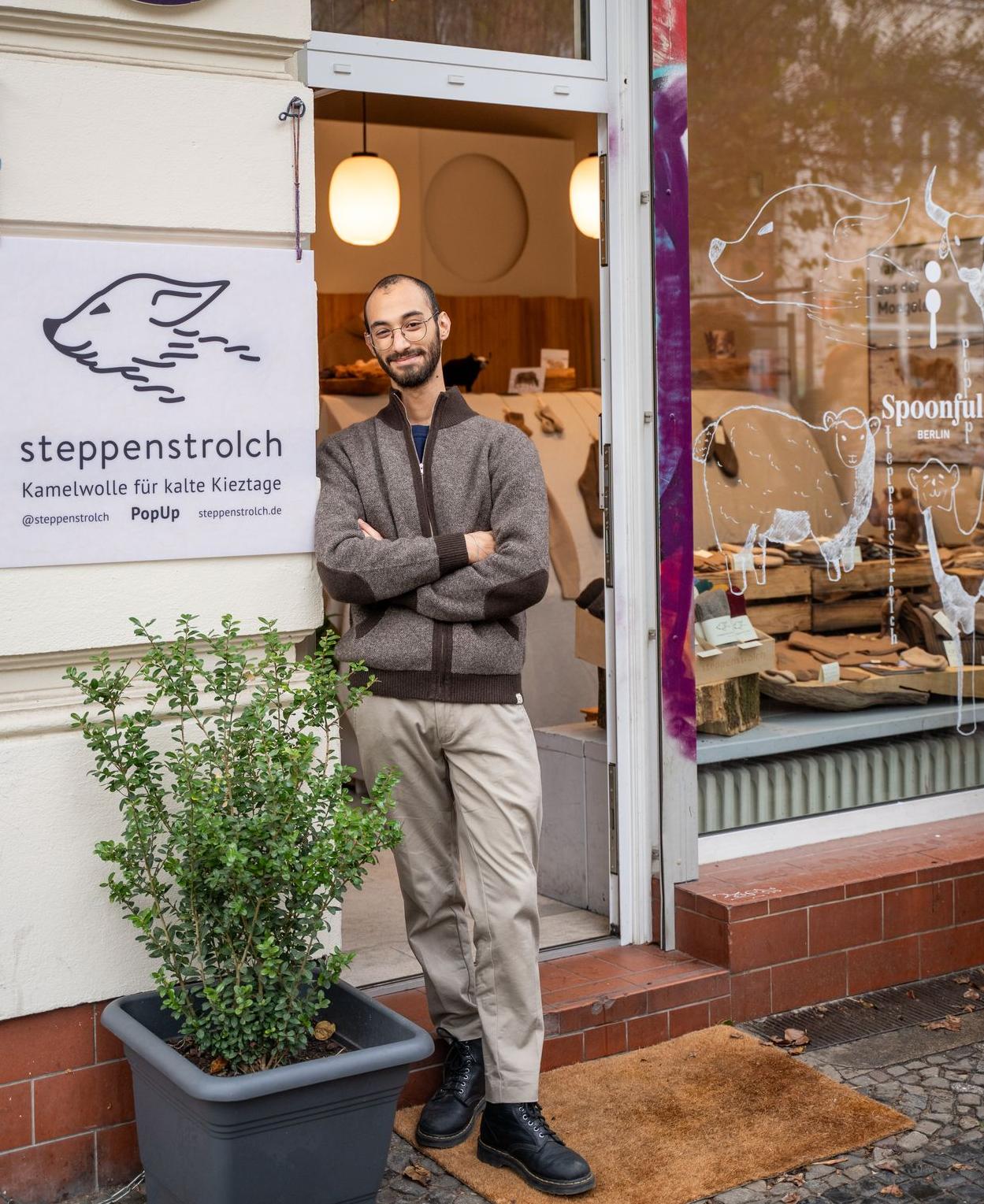 Junger Mann steht vor einem Ladengeschäft mit steppenstrolch und spoonful aufschrift