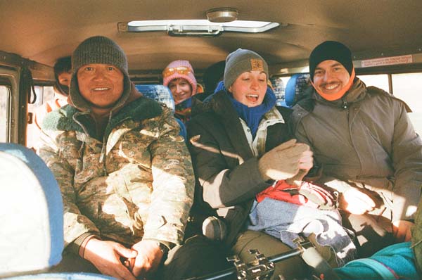 Gruppe teilt sich auf zwei Busse auf. Die Stimmung ist immer gut. Menschen sitzen auf den Hinterbänken eines Kleinbus
