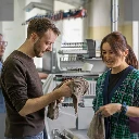 Ein Mann und eine Frau begutachten einen Schal aus Wolle