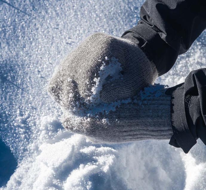 Grey gloves form snowball