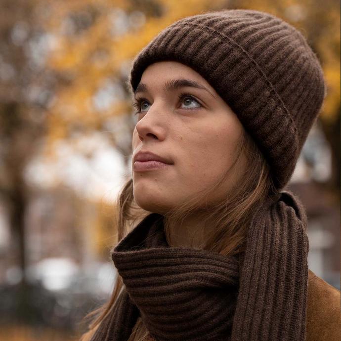 Woman with dark brown scarf and cap