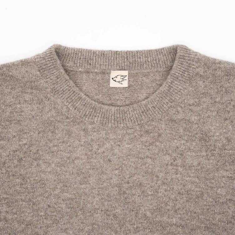 Kragen eines grauen Pullovers mit steppenstrolch Logo