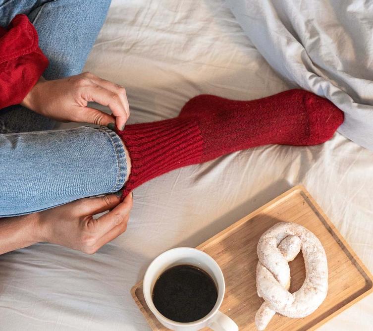 Red woollen socks are arranged next to breakfast