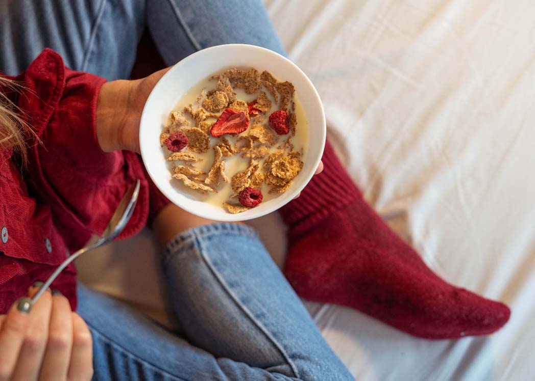 Breakfast cereal with red socks on bed