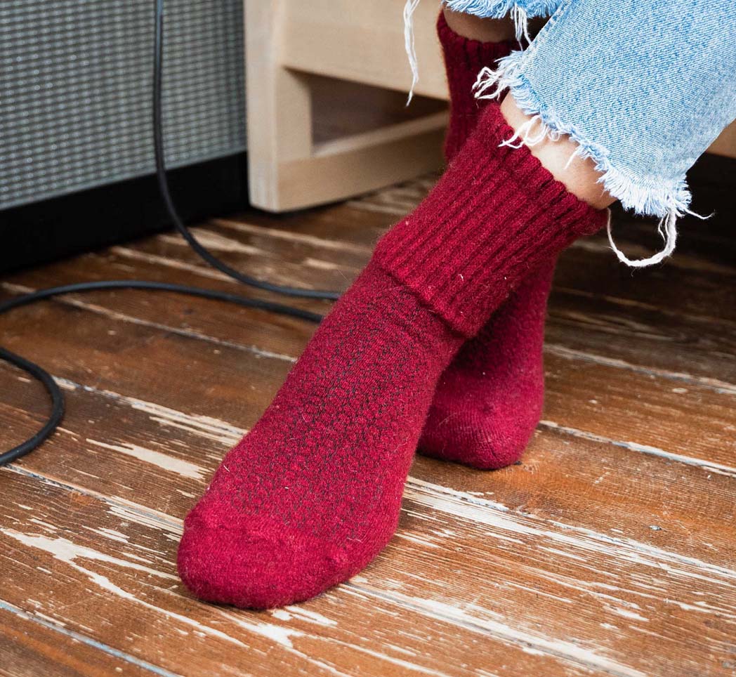 red woollen socks on wooden floor